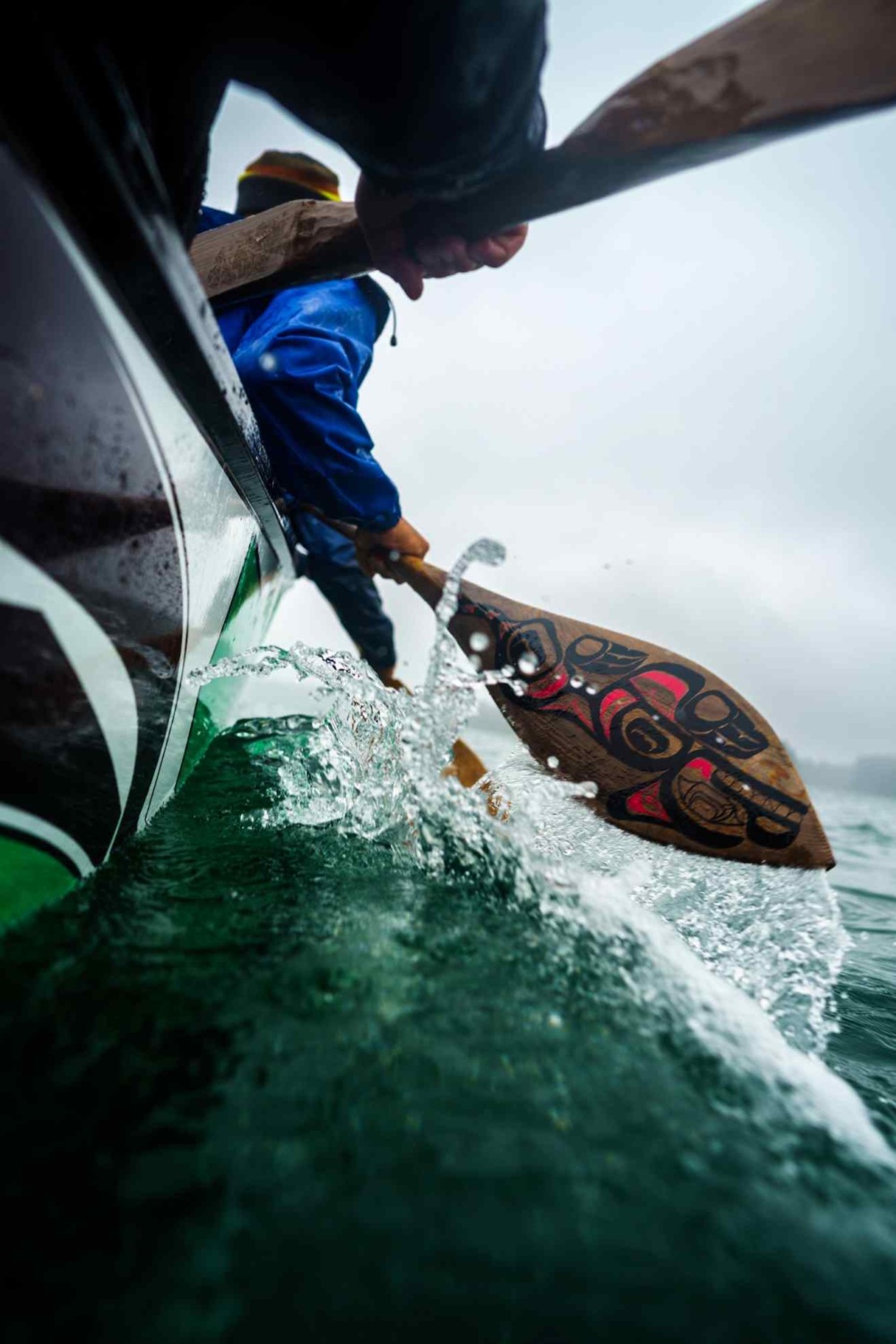 Yakutat Surf Club participants practice traditional canoeing between surf sessions. Cedar Paddles push through the cold waters near Yakutat, Alaska.