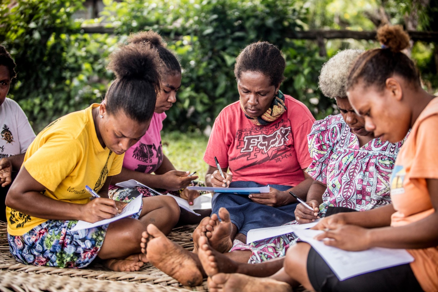 A group of women inn Erromango, Vanuatu sitting on the ground learning about strategies for disaster survival.