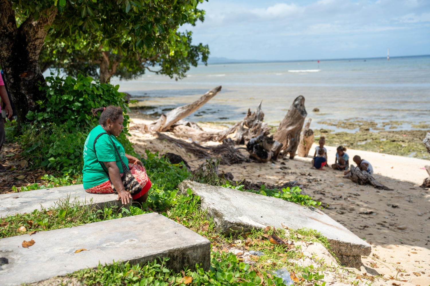 Woman sitting on gravestone on beach