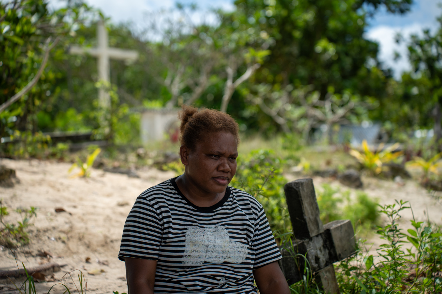 Woman sits in village graveyard