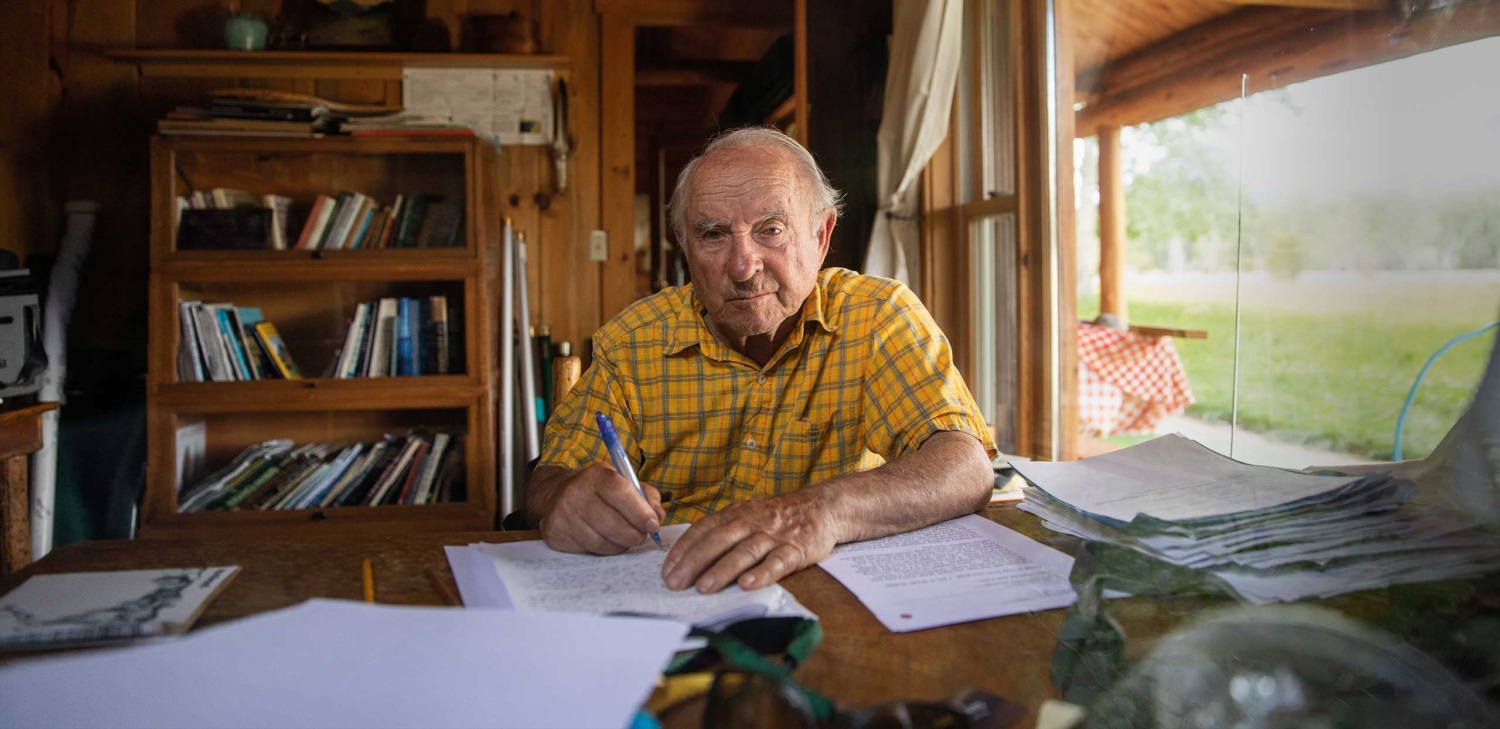 Yvon Chouinard sitting at a desk with a pen in hand